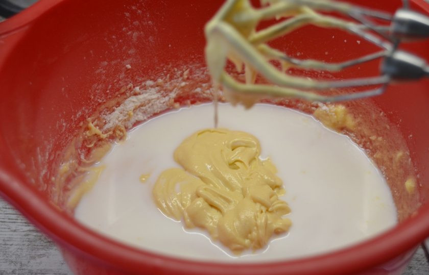 1. Этап. Капкейки с соленой карамелью: Влейте в тесто молоко, взбейте еще раз.