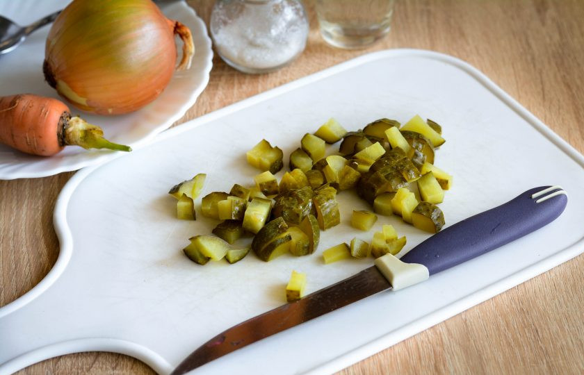 1. Этап. Салат с перловкой на зиму: Соленые огурцы нарежьте кубиками.