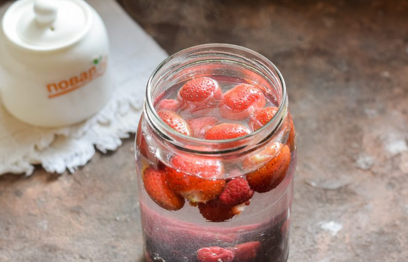 1. Этап. Компот из клубники, малины и смородины на зиму: Доведите до кипения чистую воду, залейте крутой кипяток в банку. На горлышко банки набросьте крышку и оставьте на 10 минут. Спустя время воду слейте в кастрюлю, доведите до кипения и верните в банку, снова оставьте на 10 минут в покое.