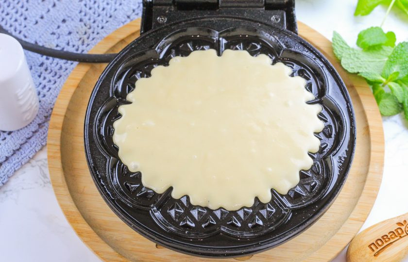 1. Этап. Хрустящие вафли на маргарине: Разогрейте вафельницу и смажьте панели в первый раз растительным или сливочным маслом. Выложите в середину 2-3 ст.л. приготовленного теста.