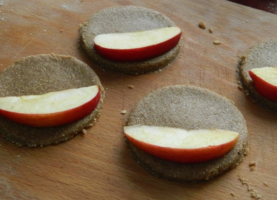 1. Этап. Печенье из гречнево-овсяной муки с яблоком: 5. Дальше раскатываем тесто не очень тонко, вырезаем кружочки стаканом и выкладываем на одну половину дольку яблока.