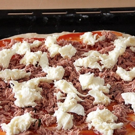 1. Этап. Пицца с тунцом: Моцареллу слегка отожмите и затем порвите на кусочки. Кусочки равномерно распределите по пицце.