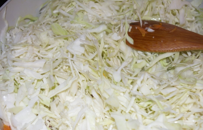 1. Этап. Солянка по-грузински: Добавьте капусту. Сразу перемешайте. Уменьшите огонь и тушите под крышкой, помешивая периодами.