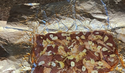 1. Этап. Утиные голени на косточке в мешочках: Маринованное мясо выложить на фольгу, добавить чеснок (порезанный пластинами), имбирь (потертый на терке). Завернуть мясную массу в фольгу, и в разогретую духовку до 180 *С на 30 минут