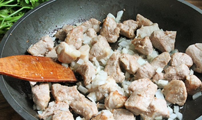 1. Этап. Тушеная картошка со свининой на сковороде: Как только выпарится жидкость, выделяемая мясом, добавляем измельченный репчатый лук. Жарим 5 минут, постоянно помешивая.