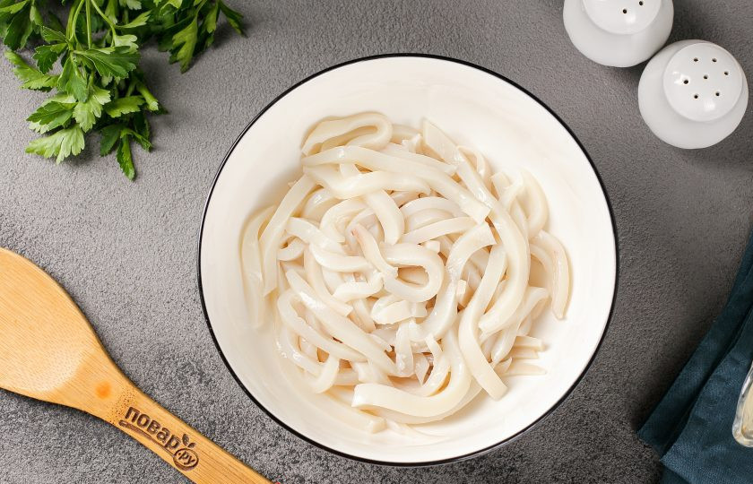 1. Этап. Кальмаровый салат с огурцом: Затем обдайте холодной водой, снимите шкурку, удалите внутренности и хорошо промойте. Нарежьте небольшой соломкой.