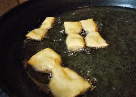 1. Этап. Печенье Бантики: Разогрейте сковороду, налейте масла так, чтобы бантики в них могли плавать. Выкладывайте печенье и обжаривайте несколько минут до румяного цвета, пока бантики слегка не увеличатся.