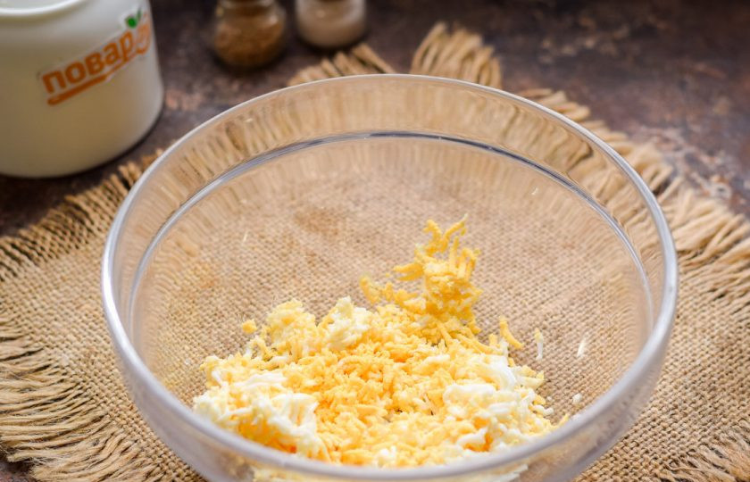 1. Этап. Авокадо фаршированное креветками: Куриное яйцо почистите и натрите на мелкой терке. Переложите яйцо в миску.