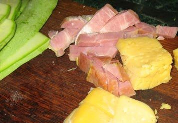 1. Этап. Кабачки с ветчиной: Сыр и ветчину нарезать небольшими брусочками. Размер брусочка равен ширине полоски из кабачка.