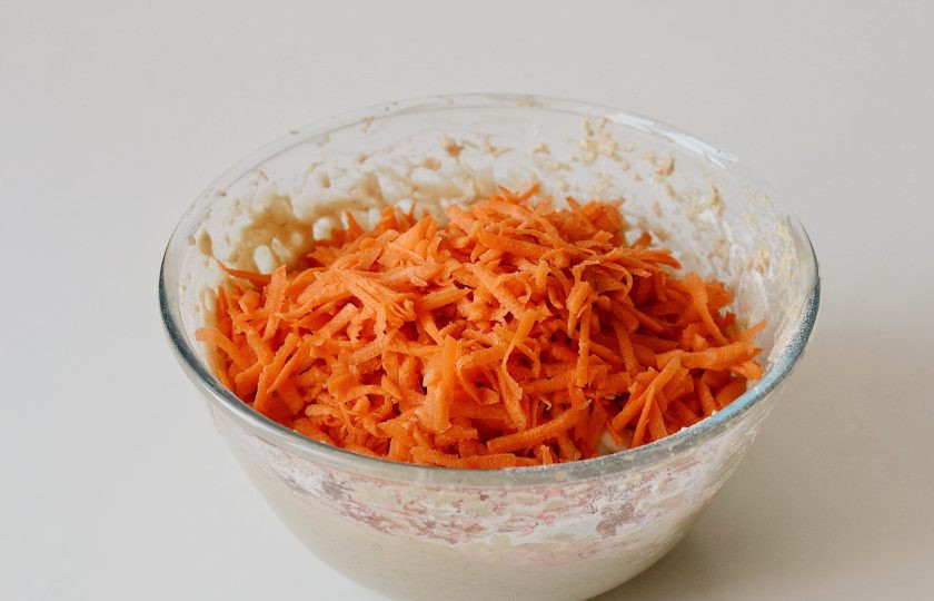 1. Этап. Постный морковный кекс: Добавьте сухие ингредиенты. Размешайте. Затем добавьте в миску тертую морковь и апельсиновую цедру, еще раз размешайте все.