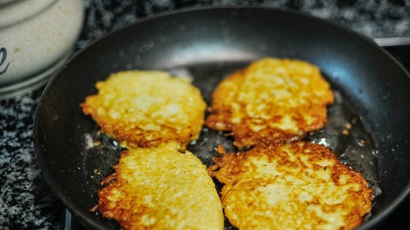 1. Этап. Драники с грибным соусом: 6. На сковороде разогрейте растительное масло. Ложкой выкладывайте картофель, формируя тоненькие оладьи. Жарьте их на среднем огне до румяности с двух сторон.