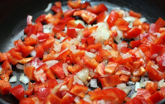 1. Этап. Миш-маш болгарский: Далее добавляем в сковороду кубиками нарезанный красный перец, перемешиваем с луком и тушим на среднем огне 3-4 минуты.