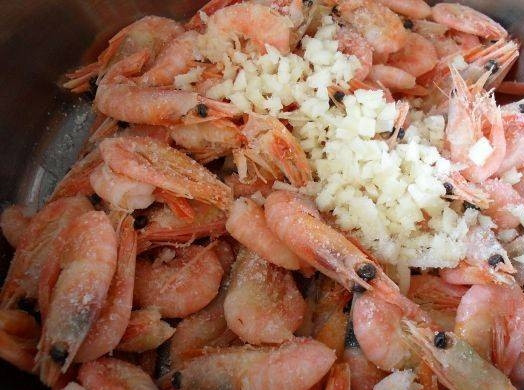 1. Этап. Креветки на мангале: К размороженным креветкам в глубокой миске добавьте чеснок и соль.