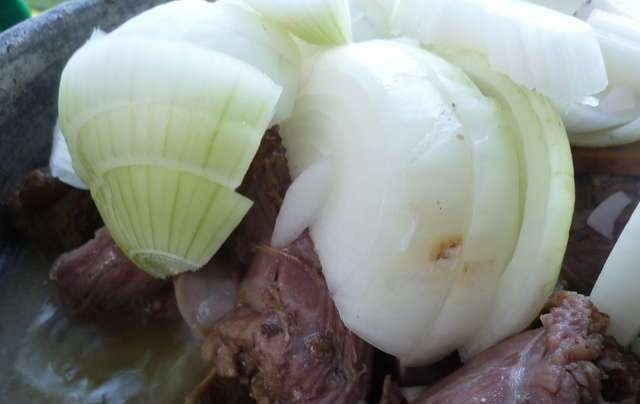 1. Этап. Утиные желудки: Лук почистите и крупно нарубите. Добавьте его в кастрюлю и тушите уже без крышки.