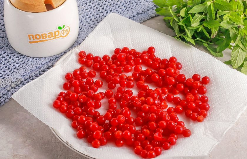 1. Этап. Заморозка калины на зиму: Выложите на тарелку бумажную салфетку или полотенце и высыпьте на нее промытые ягоды. Промокните сверху салфеткой.