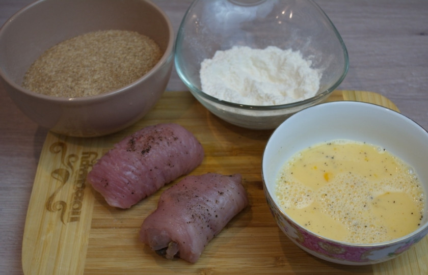 1. Этап. Котлеты по-киевски с грибами: Так сформируйте все рулетики. Подготовьте панировку. Смешайте 2 яйца с 3 ложками молока. Взбейте. Это будет кляр. В отдельной миске подготовьте муку и панировочные сухари. Окуните рулетик в яичный кляр, после — в муку, после — снова в кляр, после — в панировку. Сформируйте котлету. Обжарьте ее на сковороде с растительным маслом, но уровень растительного масла должен быть до середины котлеты.