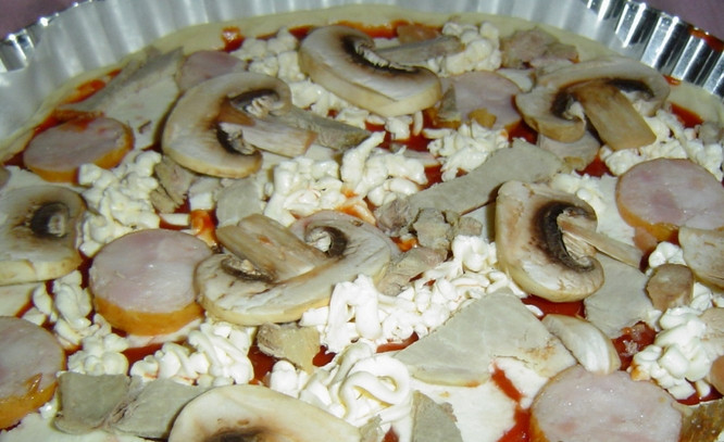 1. Этап. Сырная пицца: Затем кладем кусочки колбасы и шампиньоны, порезанные ломтиками.