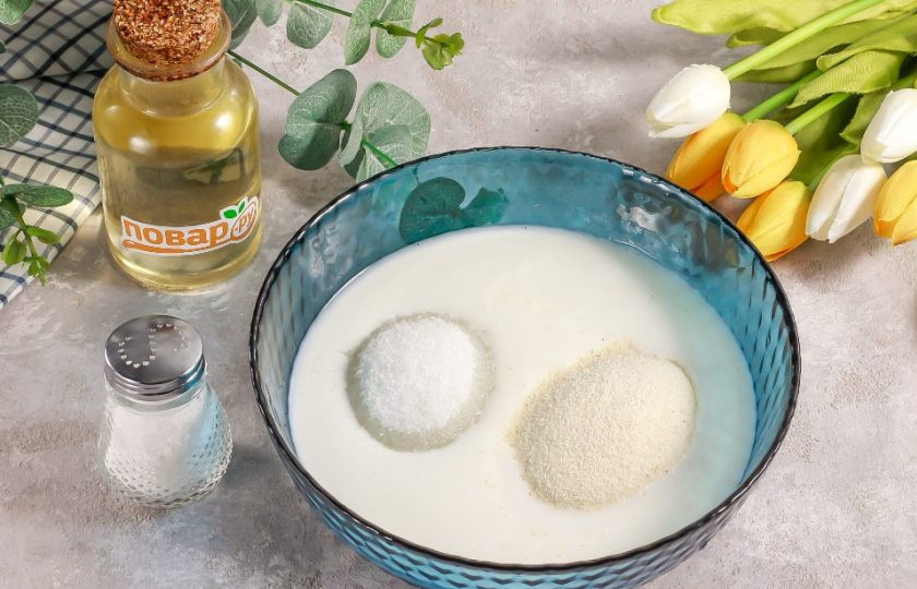 1. Этап. Манно-яблочный пирог Сочный: Кефир любой жирности перелейте в глубокую емкость. Всыпьте туда же сахар, соль и манную крупу. Тщательно перемешайте и оставьте при комнатной температуре на полчаса минимум. Время от времени перемешивайте, чтобы манная крупа набухла равномерно.