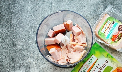 1. Этап. Закусочное печенье с ветчиной и сыром: Ветчину и филе грудки порежьте кубиком и положите в чашу блендера.