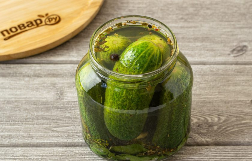1. Этап. Маринованные огурцы с уксусом: Влейте в банку уксус. Затем влейте горячий маринад.