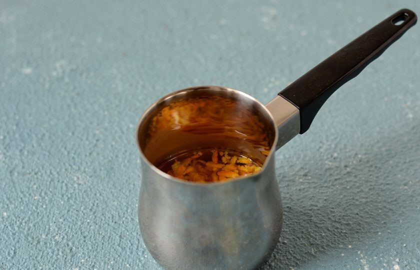 1. Этап. Апельсиновое какао: В ковшике нагрейте воду, ванильный сироп, сахар и цедру апельсина. Доведите до кипения и снимите с плиты.