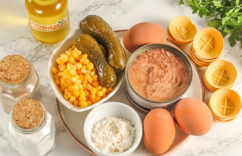 1. Этап. Салат с тунцом и кукурузой в тарталетках: Подготовьте указанные ингредиенты. Используйте консервированного тунца в масле или стружку тунца. Куриные яйца отварите заранее в течение 12 минут, а затем резко остудите в ледяной воде.