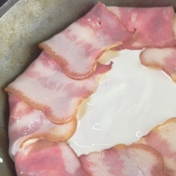 1. Этап. Индейка, запеченная слоями: Полить сметаной и завернуть полоски бекона.