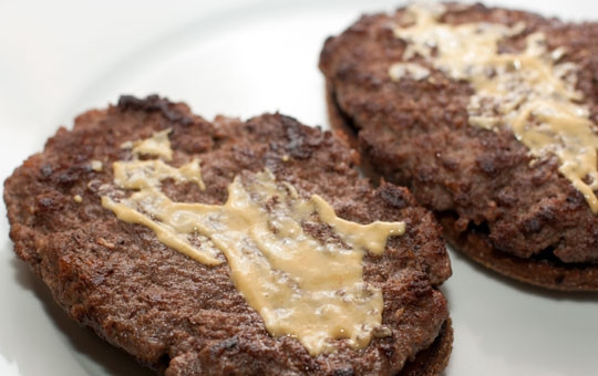 1. Этап. Домашний гамбургер с ржаным хлебом: Формируем наши гамбургеры следующим образом. Кладем хлебец, слегка смазываем его томатной пастой, кладем на него котлетку. Котлетку смазываем горчицей.