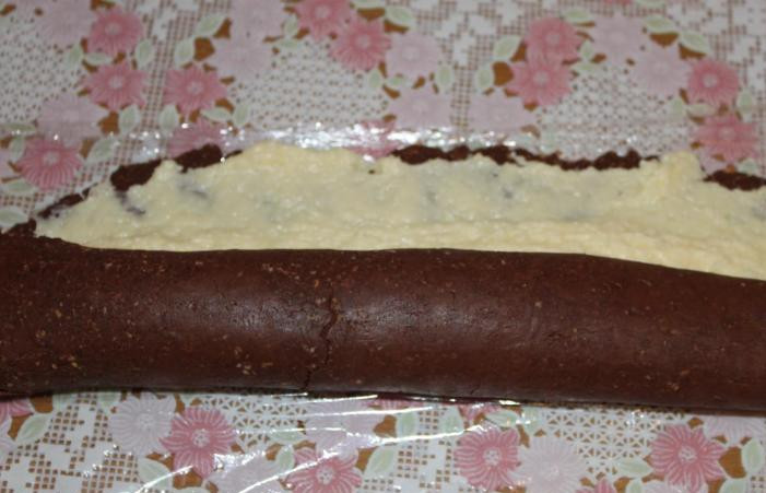 1. Этап. Рулет Mинутка из печенья: Аккуратно приподнимаем край пленки и сворачиваем тесто рулетом.