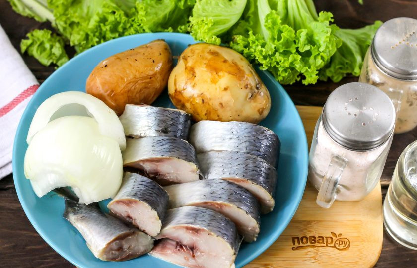 1. Этап. Салат Русская закуска: Подготовьте указанные ингредиенты. Слабосоленую сельдь заранее разделайте, промойте, нарежьте на части. Картофель отварите, а лук — очистите от кожуры и промойте в воде.