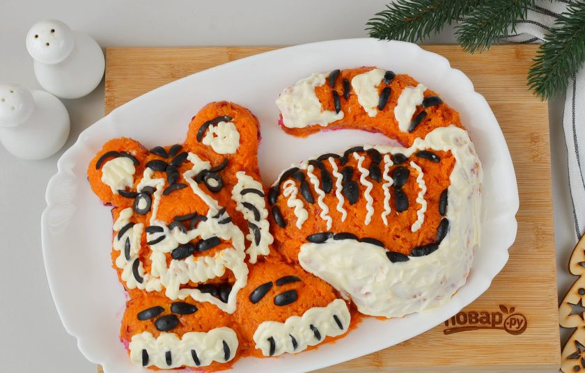 1. Этап. Салат Тигр в шубе на Новый год: Майонезом и маслинами декорируйте салат, чтобы получился тигренок.