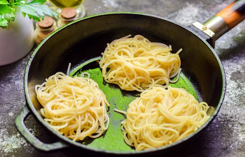 1. Этап. Гнезда с морепродуктами: Спагетти отварите до полуготовности. Переложите спагетти в виде гнезд в сковороду.