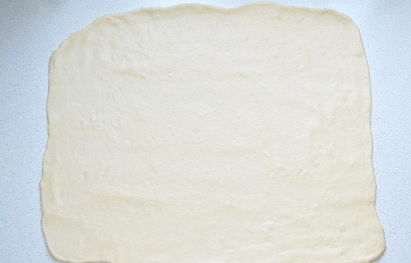 1. Этап. Булочки с колбасой и сыром в духовке: Разделите тесто на 2-3 части. Каждую раскатайте тонким пластом.