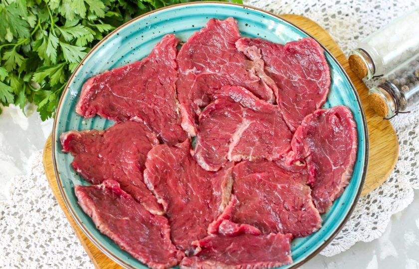1. Этап. Карпаччо из говядины: Промойте мясо в воде, подморозьте в морозильной камере примерно 10-15 минут в зависимости от величины куска, чтобы оно легче нарезалось. Аккуратно нарежьте слайсами с помощью острого ножа. Ломтики мяса должны быть очень тонкими. Выложите нарезку в миску или на тарелку.