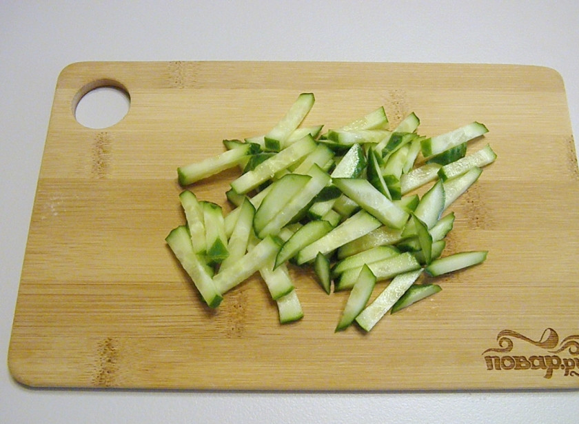 1. Этап. Салат к белому вину: Свежий огурчик тщательно вымойте под проточной водой и порежьте кубиками или соломкой.