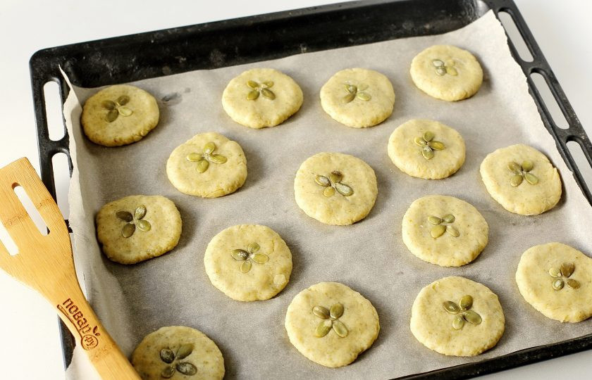 1. Этап. Печенье с тыквенными семечками: Прижмите каждый шарик слегка рукой и украсьте верх по желанию тыквенными семечками, вдавливая их в тесто. Запекайте в духовке при температуре 190 градусов около 25 минут.