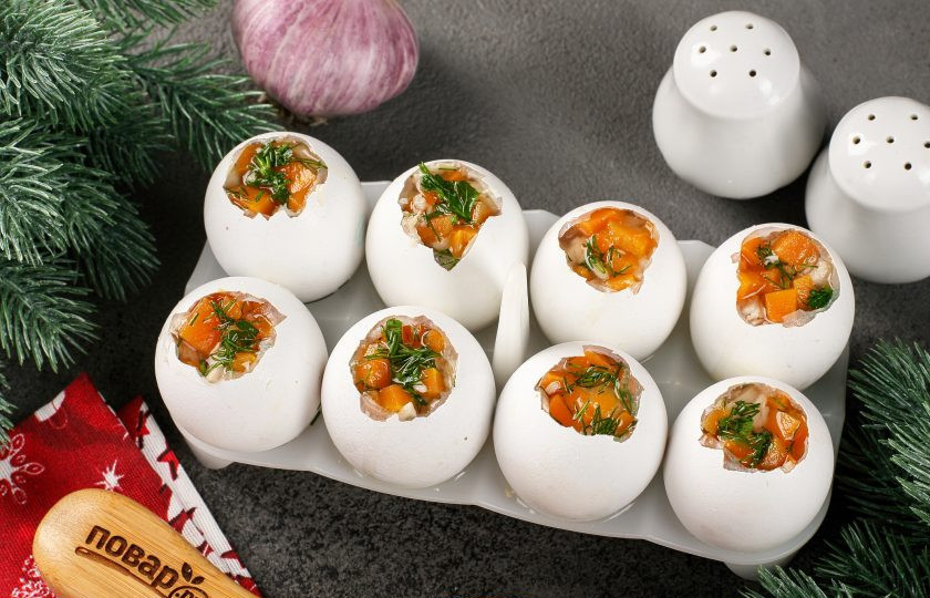 1. Этап. Заливные Драконьи яйца на Новый год 2024: На дно каждой скорлупы выложите по листику петрушки и зёрна граната. Добавьте чуть-чуть бульона, примерно 1 ст.л. Затем чередуя выложите грудку и морковь и залейте всё бульоном. Уберите в холодильник минимум на 4 часа. Я оставляю на ночь.