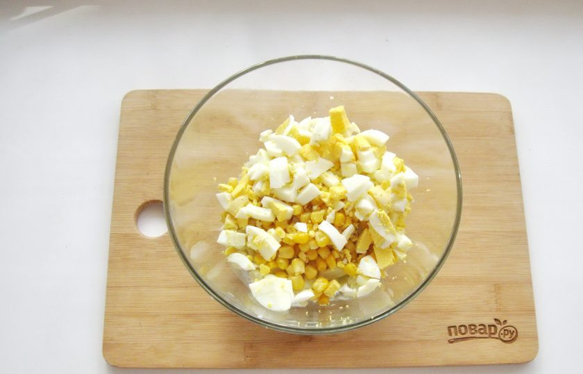 1. Этап. Салат из цветной капусты с крабовыми палочками: Яйца сварите вкрутую, охладите, очистите и нарежьте кубиками. Выложите в салат.