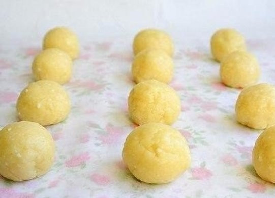 1. Этап. Творожно-шоколадное печенье: Затем нужно из теста сформировать аккуратные шарики. Делайте это так, чтобы шоколад оказался внутри и был полностью покрыт слоем теста. Это нужно для того, чтобы шоколад не вытекал на противень при запекании печенья.