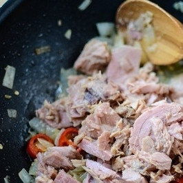 1. Этап. Паста с тунцом консервированным: 2. К обжаренному луку и перцу добавьте тунец. Раздробите его лопаточкой и прогрейте в течение 2-3 минут.