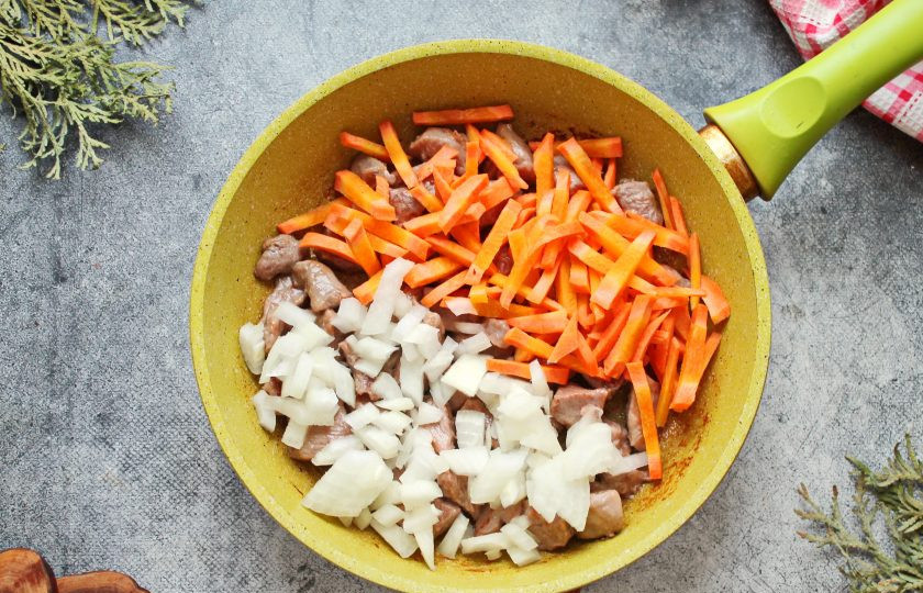 1. Этап. Индейка с рисом и овощами: Репчатый лук порежьте как вам нравится, морковь соломкой и выложите все в сковороду с индейкой. Обжаривайте все на среднем огне в течение 7-8 минут, перемешивая.