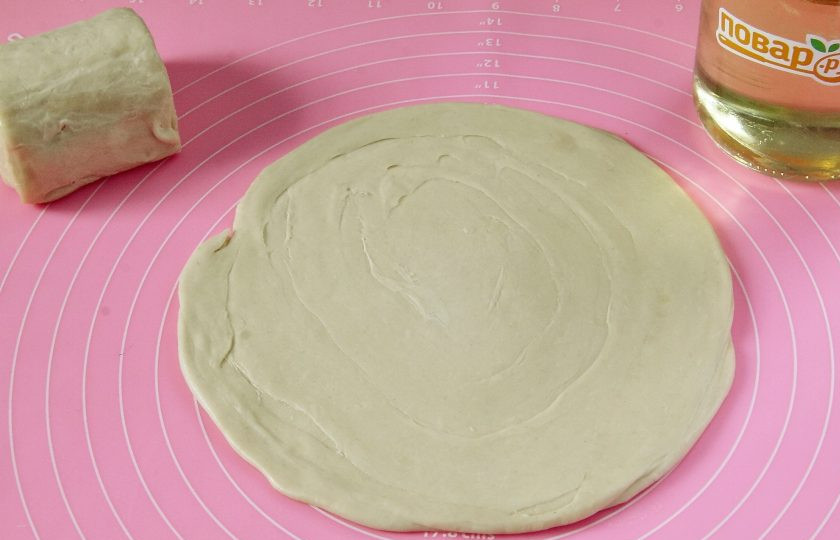 1. Этап. Узбекские слоеные лепешки: Скалку присыпьте мукой и раскатайте каждый кусочек толщиной около 2 мм и диаметром примерно 22 см.