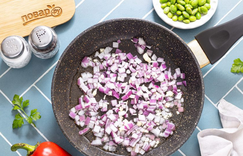 1. Этап. Паста орзо с овощами: Разогрейте на среднем огне сковороду. Обжарьте красный лук с чесноком до мягкости и прозрачности.