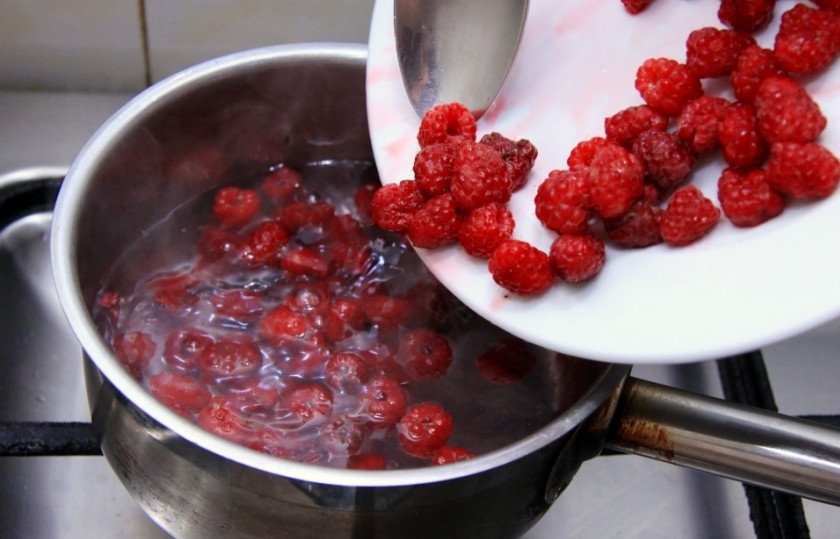 1. Этап. Ягодное желе с желатином: Вскипятите 200-250 мл воды в кастрюльке, добавьте сахар, помешивая, варите, пока сахар не растает. Потом добавьте разбухший желатин. Снова доведите до кипения. Всыпьте часть целой ягоды (можете пропустить этот шаг и оставить всю целую ягоду на украшение). Добавьте пюре из малины и варите на среднем огне минут 30, помешивая время от времени.