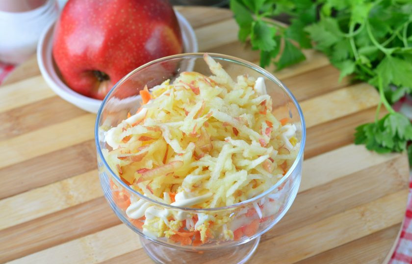 1. Этап. Салат Кудрявый с крабовыми палочками: Натрите сочное яблоко на терке и выложите следующим слоем в салат.