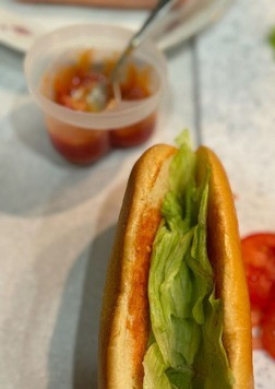 1. Этап. Хот-дог Новогодний: Булочку смазать горчично-томатным соусом, выложить листья салата