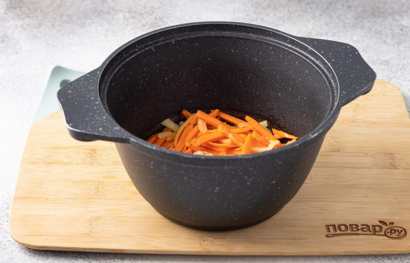 1. Этап. Суп с морской капустой и рисом: Нарежьте репчатый лук полукольцами, а морковь натрите на терке или порежьте соломкой. В кастрюле с толстым дном разогрейте растительное масло и обжарьте овощи до легкого золотистого цвета.