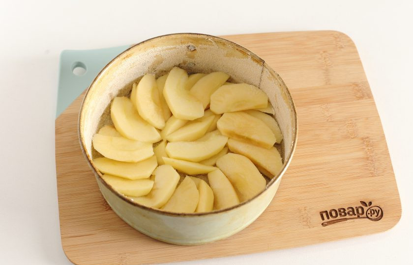 1. Этап. Шарлотка на одном яйце: Яблоки нарежьте дольками (если шкурка жесткая, то лучше ее снять) и выложите в смазанную маслом форму для запекания. Я дополнительно посыпаю форму манкой.