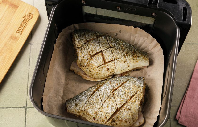 1. Этап. Дорадо в аэрогриле: Я рекомендую вам использовать пергаментную бумагу или специальные корзинки из нее, так как масла будет много! Смажьте растительным маслом пергаментную бумагу и поверхность рыбы. Выложите дорадо в чашу аэрогриля. По желанию можно набить брюшко рыбы зеленью: петрушкой, зеленым луком, ломтиками лимона.