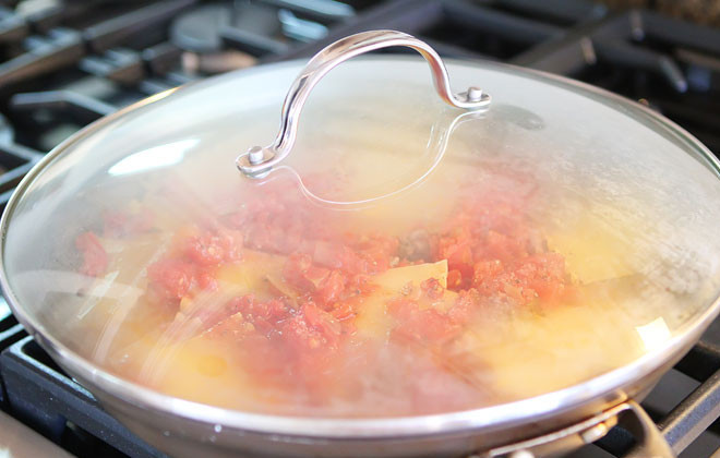 1. Этап. Лазанья на сковороде: Влейте воду, перемешайте и тушите на среднем огне.